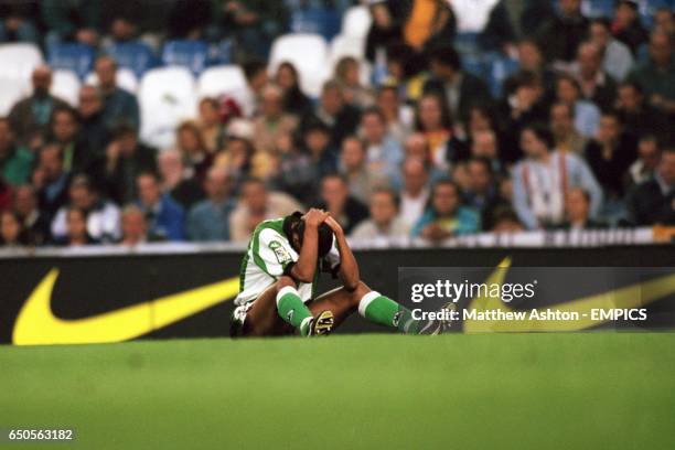 Real Betis' Denilson holds his head after a collision