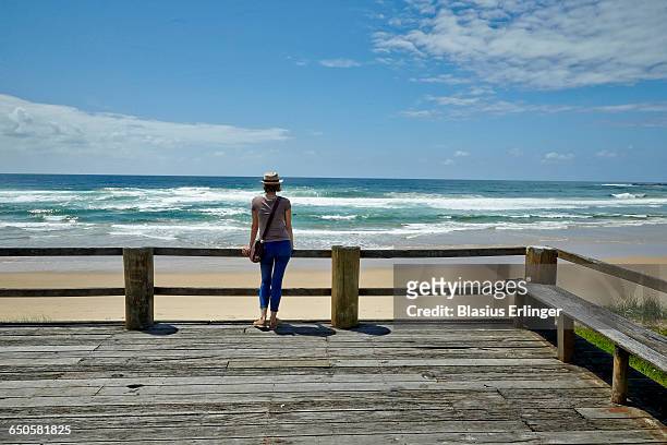 woman stretches and gazes at the ocean - cropped trousers stock pictures, royalty-free photos & images