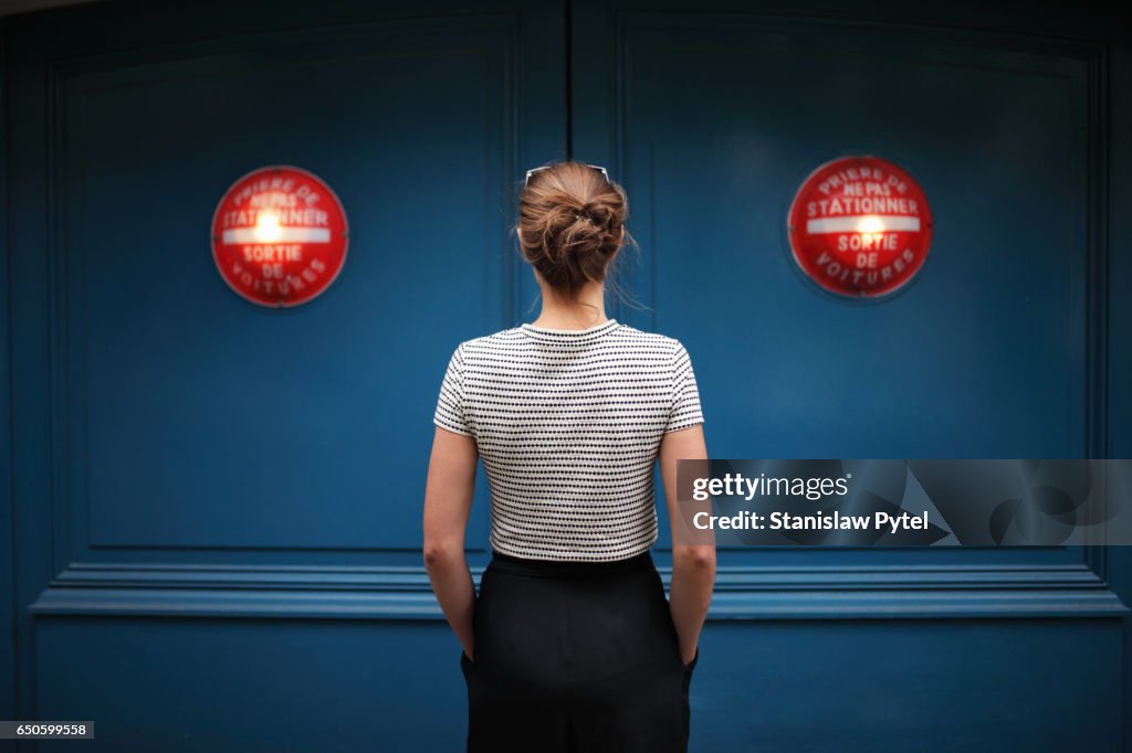 Portrait of woman against blue wall with red lights