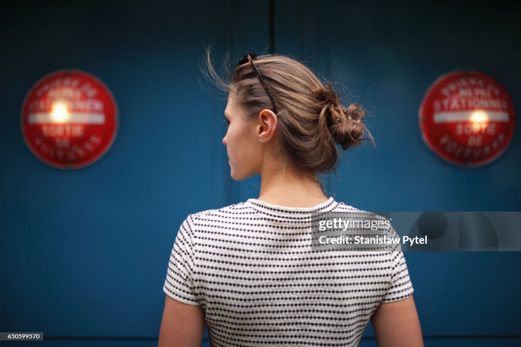 Portrait of woman against blue wall with red lights