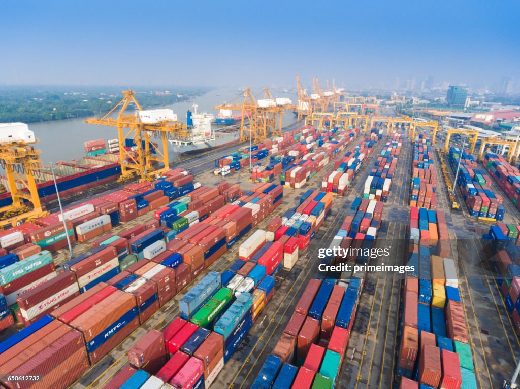 Aerial shot Container Cargo freight ship with working crane bridge in shipyard