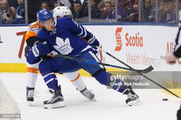 Philadelphia Flyers defenseman Andrew MacDonald ties up Toronto Maple Leafs center William Nylander behind the Flyer's net. Toronto Maple Leafs VS...