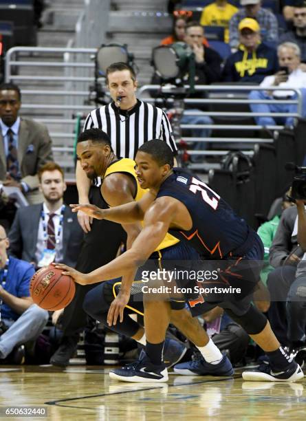 Michigan Wolverines guard Zak Irvin has the ball stolen by Illinois Fighting Illini guard Malcolm Hill during the first half in the second round of...