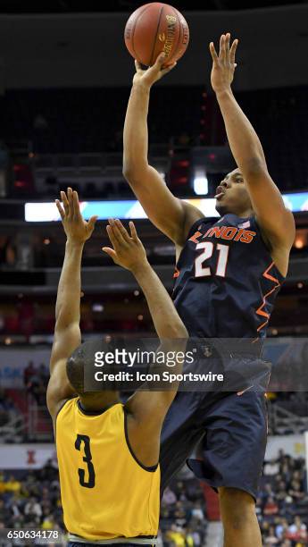 Illinois Fighting Illini guard Malcolm Hill scores against Michigan Wolverines guard Xavier Simpson in the second round of the Big 10 Tournament game...