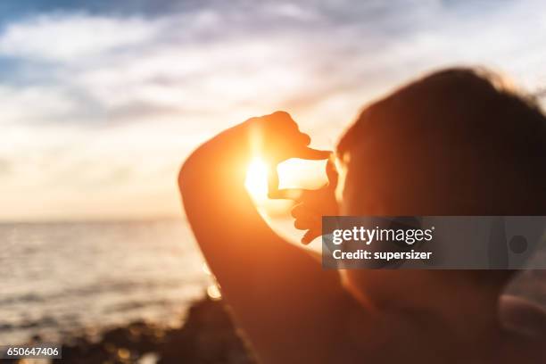 sol no quadro - dedos fazendo moldura - fotografias e filmes do acervo