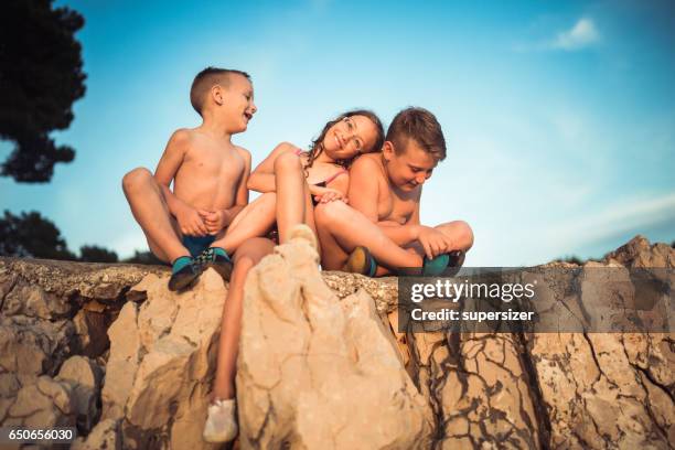 three friends on the rocky beach - croatia girls stock pictures, royalty-free photos & images