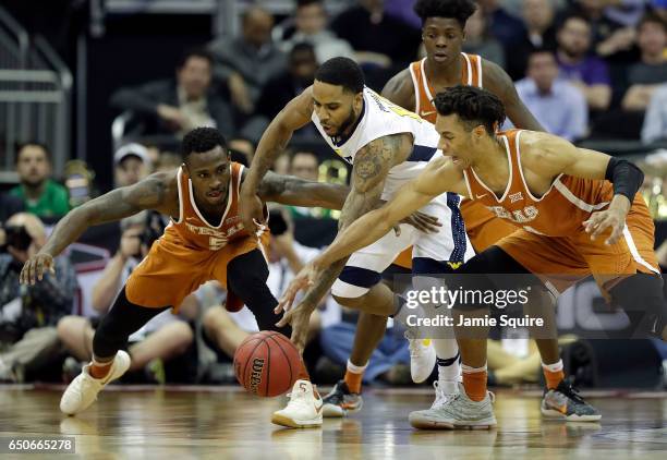 Tarik Phillip of the West Virginia Mountaineers competes with Kendal Yancy and Mareik Isom of the Texas Longhorns during the quarterfinal game of the...