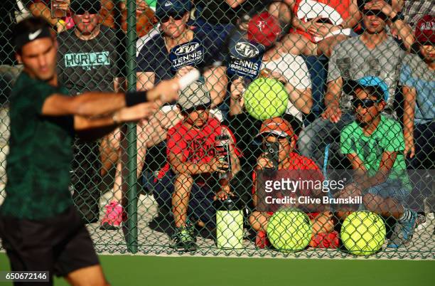 Roger Federer of Switzerland is watched by a wall of fans as he hits during a practice session on day four of the BNP Paribas Open at Indian Wells...