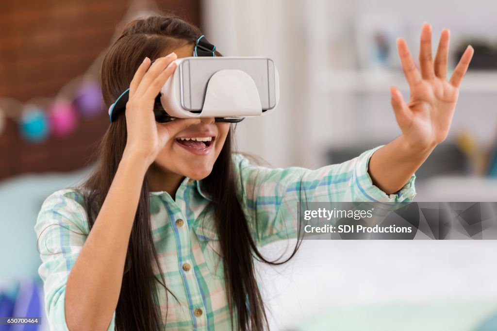 Preteen girl plays with virtual reality headset