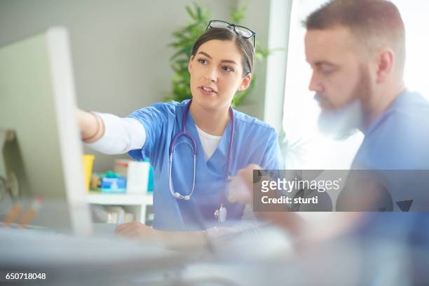 junge mediziner diskutieren notizen - communication nurse stock-fotos und bilder