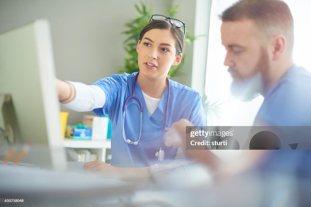 Young medical professional discussing notes