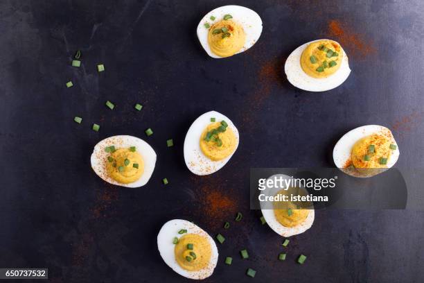 deviled eggs topped with green onion and paprika - hard boiled eggs stock-fotos und bilder