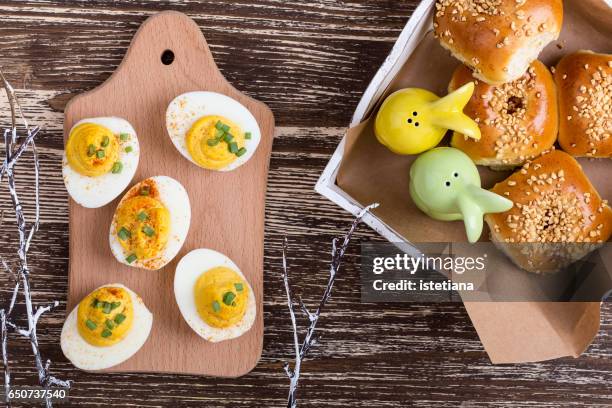 deviled eggs and homemade buns on easter table - deviled egg stock pictures, royalty-free photos & images