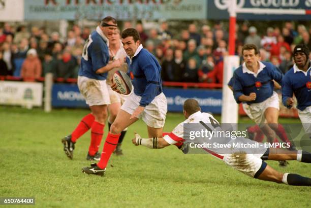 Jean Luc Sadourny of France eludes the despairing dive of England's Leon Lloyd
