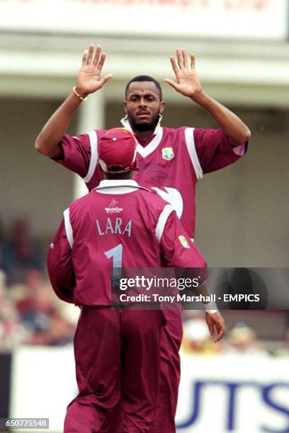 West Indies' Courtney Walsh celebrates with Brian Lara after Lara caught New Zealand's Matthew Horne