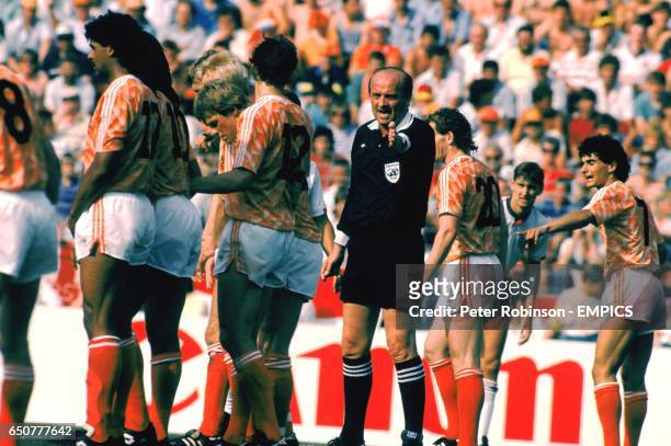 The referee instructs the Holland wall to move back another yard