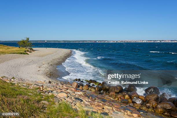 pebble beach with stone breakwater - helsingør stock-fotos und bilder