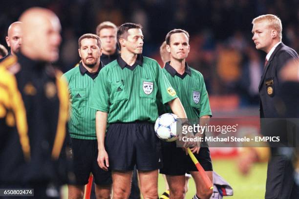 Referee Alain Sars and his assistants Bruno Faye and Pierre Renaudin wait to be escorted off after a controversial end to the match