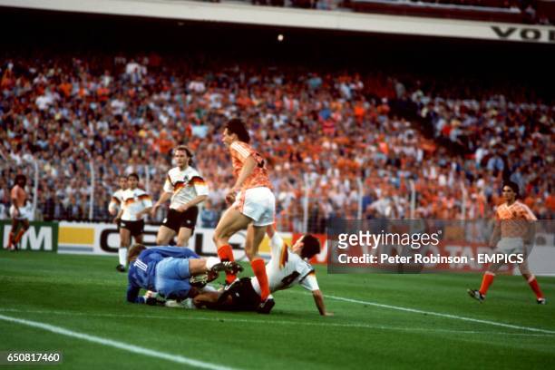 Holland's Marco Van Basten collides with West Germany goalkeeper Eike Immel and Jurgen Kohler .