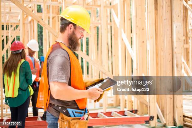 construction workers in building site with digital tablet. - machismo imagens e fotografias de stock