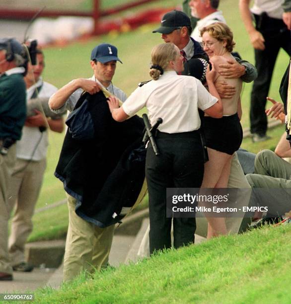 Streaker is covered up by a police officer