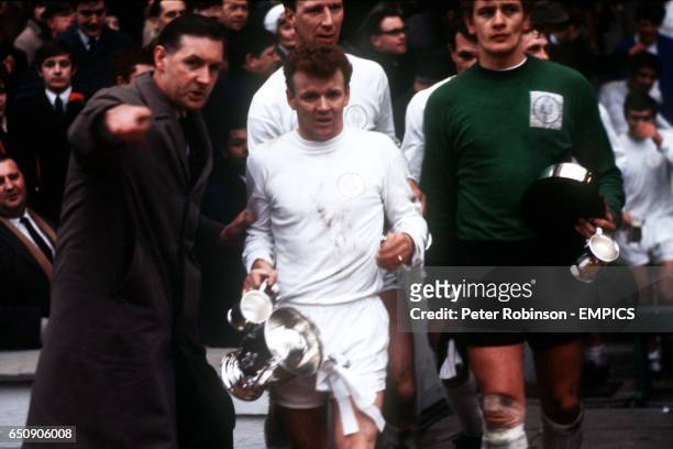 Leeds United captain Billy Bremner and goalkeeper Gary Sprake walk down the Wembley steps with the League Cup and their winners' tankards
