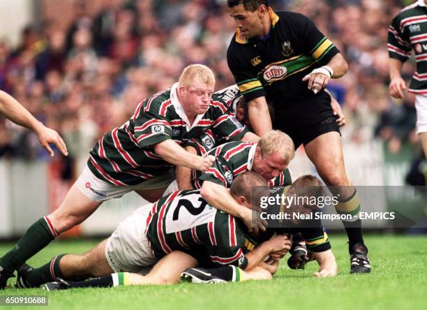 Northampton Saints' Ben Cohen is brought down by Leicester Tigers' Pat Howard, Neil Back and Dorian West