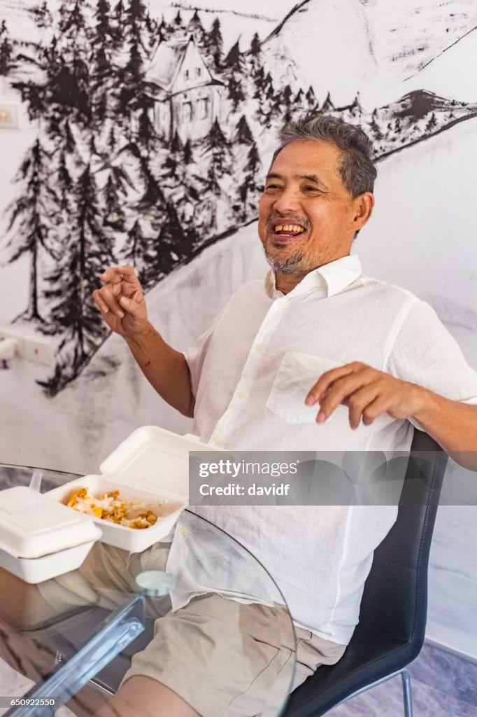 Thai Senior glücklich lachend beim Essen Essen zum mitnehmen