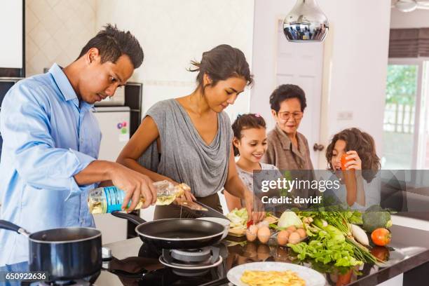 three generation asian family cooking healthy food together - eurasian ethnicity stock pictures, royalty-free photos & images