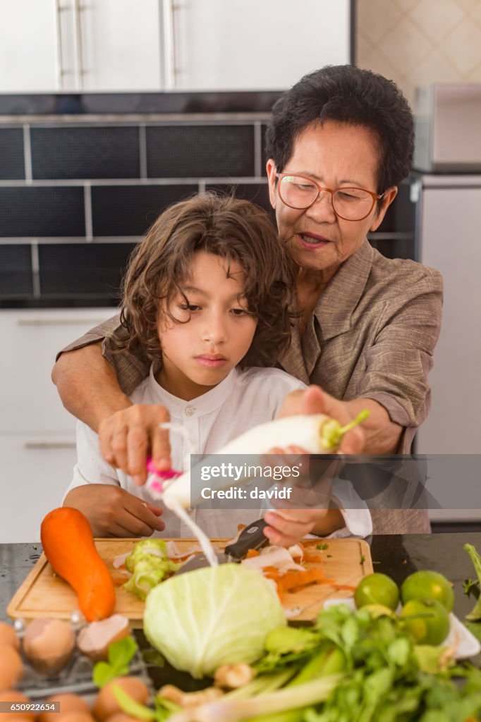 Asian Grandmother Showing Grandson How to Cook Healthy Thai Food