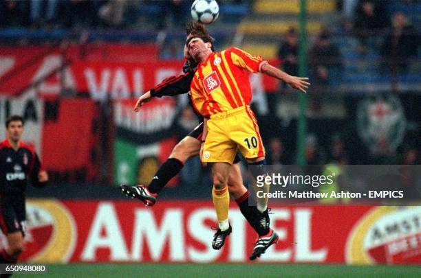 Milan's Massimo Ambrosini jumps with Galatasaray's Gheorghe Hagi