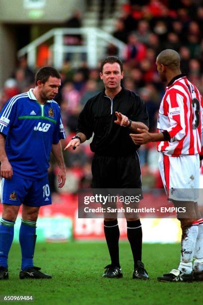 Referee Rob Styles asks one of his assistant referees to keep an eye on the behaviour of Stoke City's captain Wayne Thomas and Wigan Athletic's...