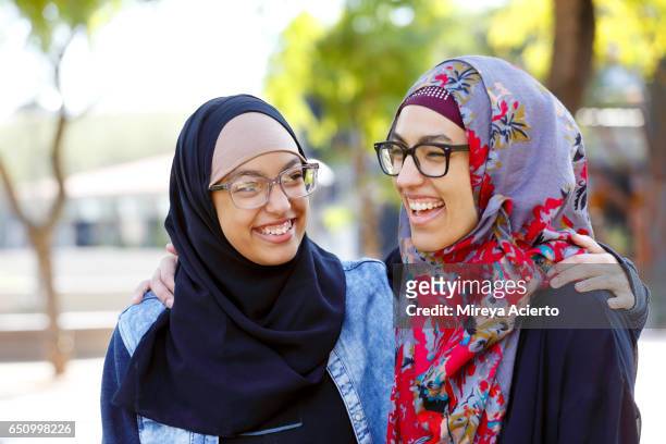 a muslim mother and daughter laughing in the park - arab family happy photos et images de collection