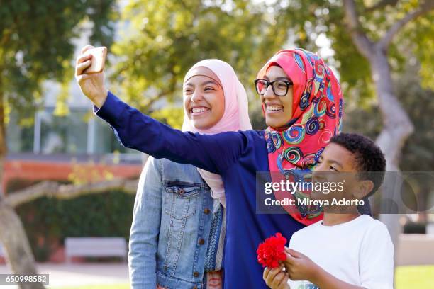 a muslim family takes a selfie in the park - arab teen photos et images de collection