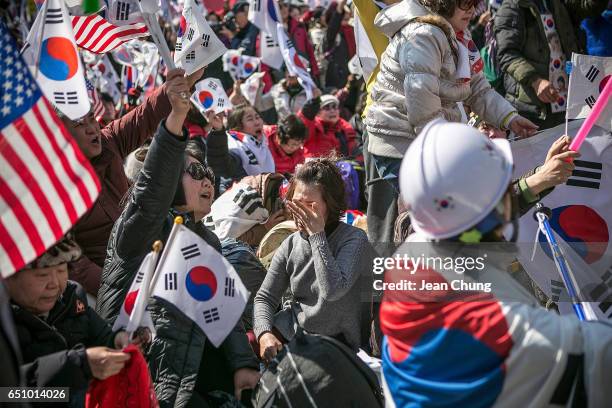 Supporters of President Park Geun-hye react emotionally as the Constitutional Court had ruled the impeachment near the court on March 10, 2017 in...