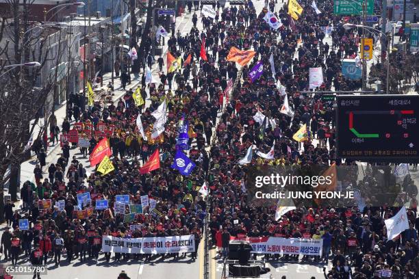 Anti-government activists march toward the presidential Blue House after the announcement of the Constitutional Court's decision to uphold the...