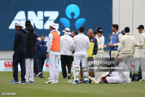 Players and team management wait for play due to a full field evacuation during day three of the First Test match between New Zealand and South...