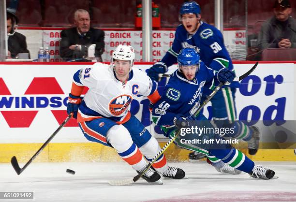 Jayson Megna of the Vancouver Canucks checks John Tavares of the New York Islanders during their NHL game at Rogers Arena March 9, 2017 in Vancouver,...