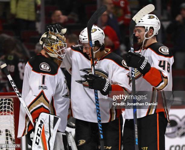 Jonathan Bernier of the Anaheim Ducks is congratulated by Brandon Montour and Logan Shaw after a shutout win against the Chicago Blackhawks at the...