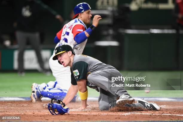 Outfielder Mitch Dening of Australia celebrates after scoring a run by a RBI single of Infielder Logan Wade of Australia to make it 1-0 in the top of...