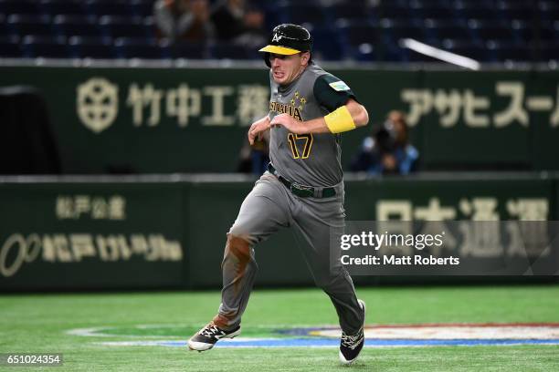 Outfielder Mitch Dening of Australia runs to the home plate to score a run by a RBI single of Infielder Logan Wade of Australia to make it 1-0 in the...