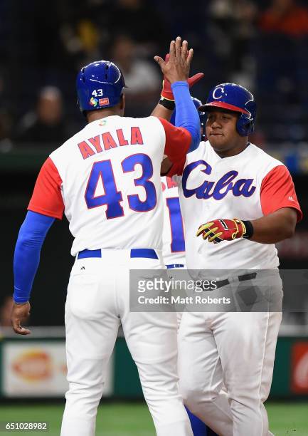 Outfielder Alfredo Despaigne of Cuba celebrates with his team mates after hitting a grand slam to make it 1-4 in the bottom of the fifth inning...