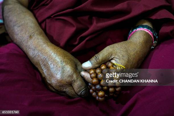 Tibetan diaspora monk prays inside a monastery marking the 58th anniversary of the 1959 Tibetan uprising against Chinese rule in New Delhi on March...