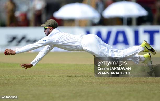 Bangladesh cricketer Shakib Al Hasan dives as he attempts to field a ball hit by Sri Lankan cricketer Upul Tharanga during the fourth day of their...