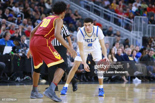 Lonzo Ball of the UCLA Bruins handles the ball against Elijah Stewart of the USC Trojans during a quarterfinal game of the Pac-12 Basketball...