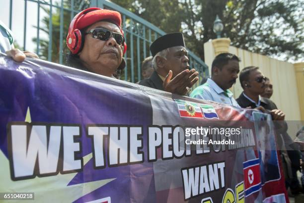 Malaysian activists hold a banner during a gathering urging Malaysia and North Korea to come up with a peaceful solution to the current diplomatic...