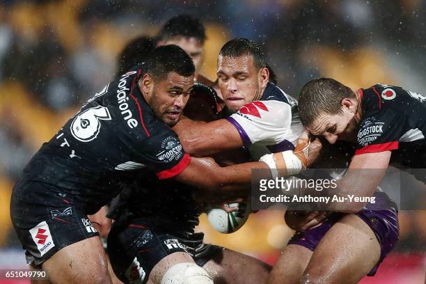 Will Chambers of the Storm is tackled by Ryan Hoffman and Sam Lisone of the Warriors during the round two NRL match between the New Zealand Warriors...