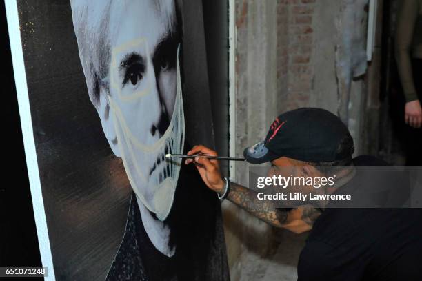 Artist Dee Cosey paints on site at Karen Bystedt's "Kings And Queens" exhibition on March 9, 2017 in Los Angeles, California.