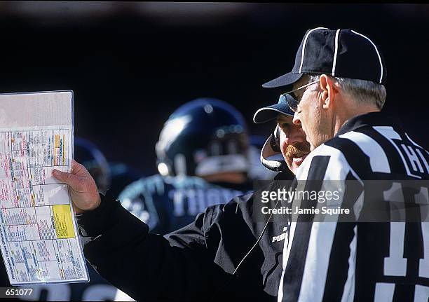 Head Coach Andy Reid of the Philadelphia Eagles shows the referee his playbook during the game against the Washington Redskins at the FedEx Field in...