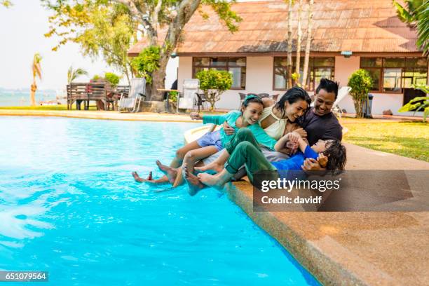 famiglia asiatica che si diverte a bordo piscina in vacanza resort - popolo eurasiatico foto e immagini stock